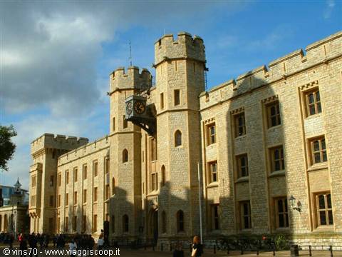 Tourists walk past the Jewel House at the Tower of London, pale stone in sunlight