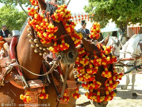 Horse decorated with red and yellow pom-poms at Spanish fair