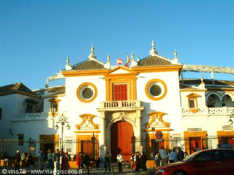 White and ochre facade of Seville's bullring, crowd at the entrance