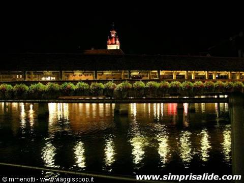 The characteristic 'flower bridge' of Lucerne, seen at night, with a wall tower in the background