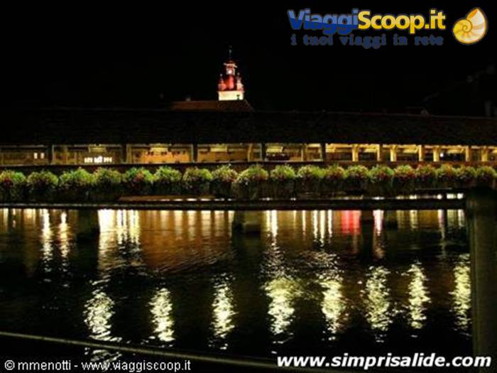 The characteristic 'flower bridge' of Lucerne, seen at night, with a wall tower in the background