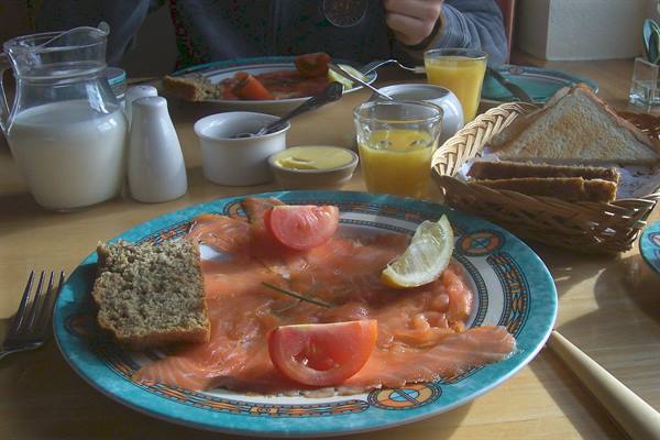 Plate of smoked salmon with tomatoes and toast at breakfast
