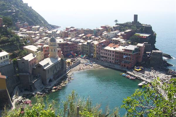 Vernazza: colorful houses by the beach, bell tower, boats in the harbor