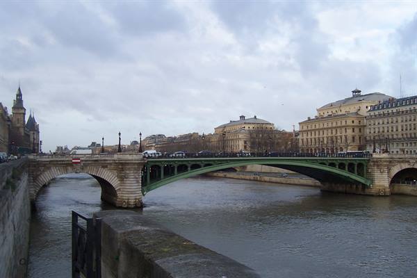 Pont Notre-Dame over the Seine in Paris, stone arch and green ironwork under cloudy sky