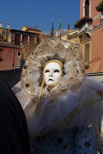Venetian carnival mask with white face, pearl necklace and golden costume