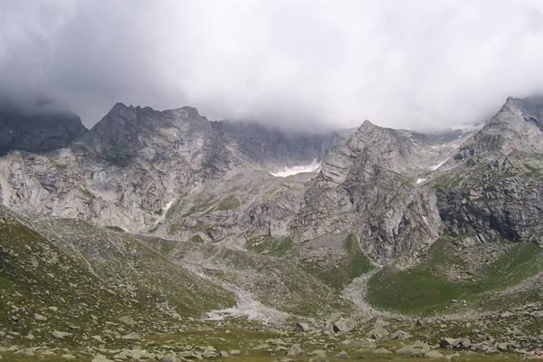 Granite peaks wrapped in clouds above a grassy rocky cirque