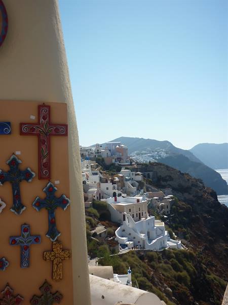 Painted ceramic crosses beside whitewashed houses in Oia, Santorini