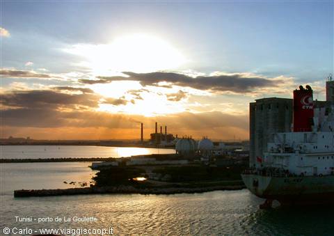 Low sun over La Goulette port, cargo ship and industrial silos