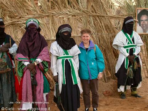 Tourist standing among veiled Tuareg men in traditional robes, tea festival, Libya