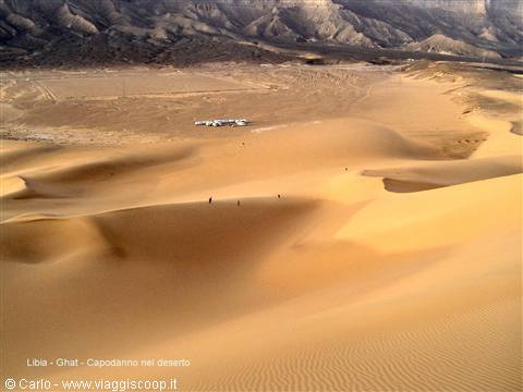 Golden sand dunes at Ghat, airplane wreck near walking figures