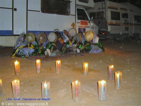Drummers sitting beside campervans, candles in the sand, Ghat