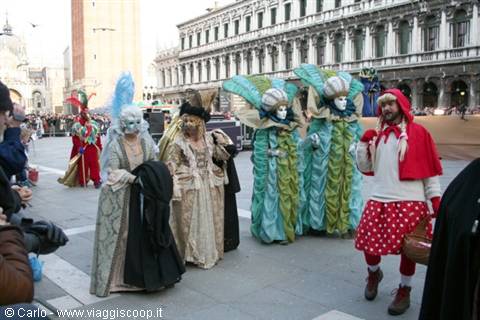Colorful masked carnival costumes parading in St Mark's Square, Venice