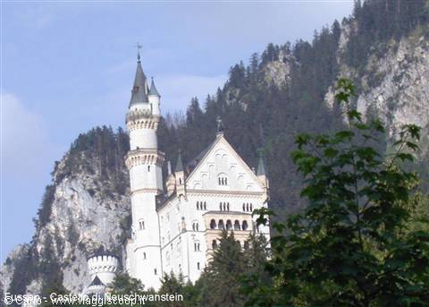 White Neuschwanstein castle among forested rocky cliffs