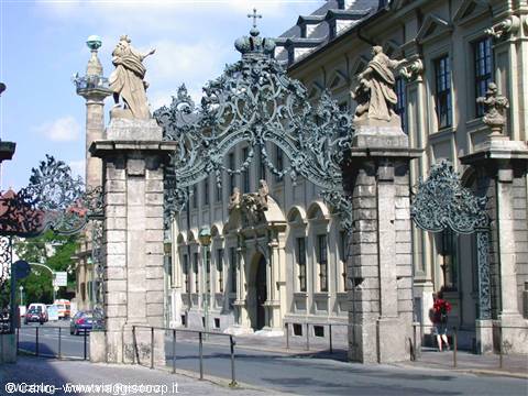 Green wrought-iron gate of the Würzburg Residenz, statues and baroque palace