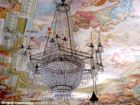 Crystal chandelier beneath a frescoed ceiling with angels and figures