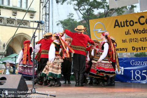 Folk dancers in traditional Polish costumes performing on Rynek square