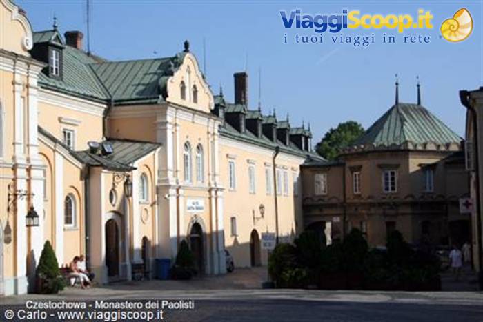 Yellow cloister of the Jasna Góra monastery in Częstochowa, green roofs, seated tourists
