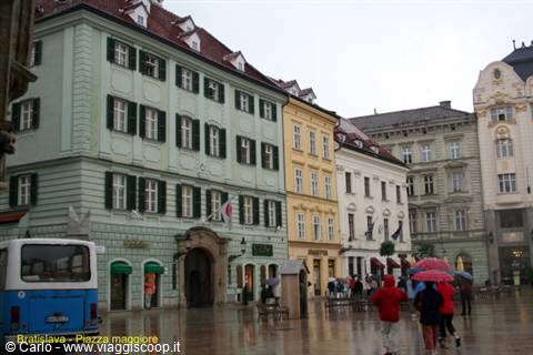 Bratislava main square in the rain, colorful umbrellas in front of historic buildings