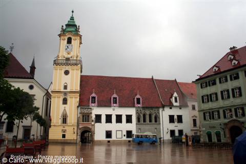 Bratislava main square in the rain, yellow old town hall with its clock tower