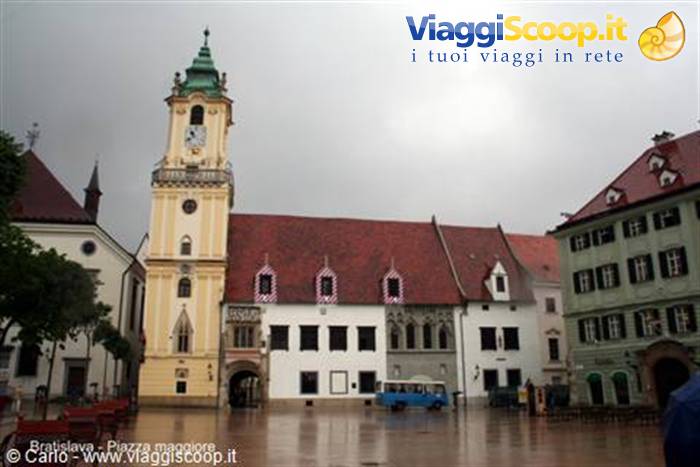 Bratislava main square in the rain, yellow old town hall with its clock tower