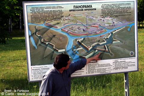 Man points at the panorama map of Brest Fortress on an info board