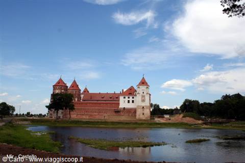 Mir Castle's red brick towers rise above ponds and green meadows