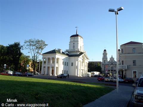White neoclassical town hall with tower, Minsk, morning light, parked cars