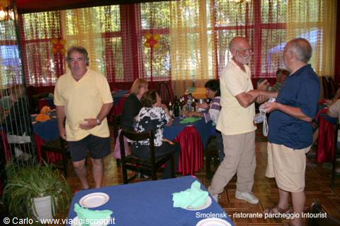 Tourists standing among set tables in the Smolansk restaurant