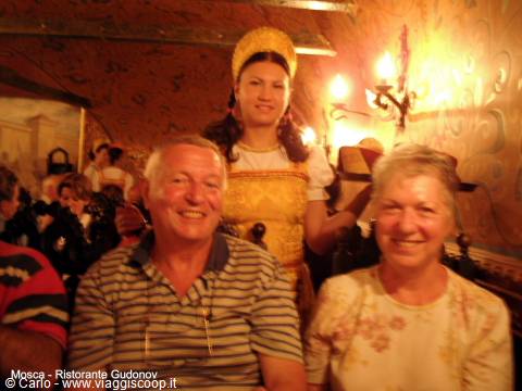 Smiling couple at Gudonov restaurant, Moscow, waitress in traditional Russian costume