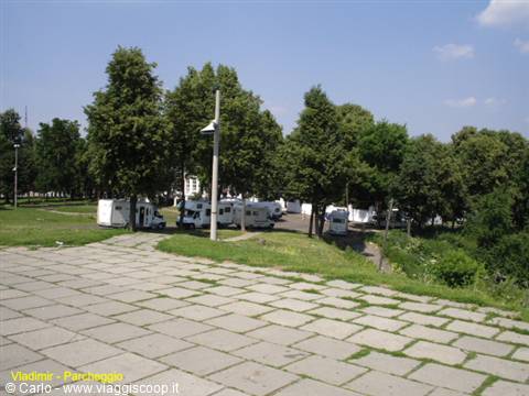 Vladimir: campervans parked among trees, grey stone-paved square