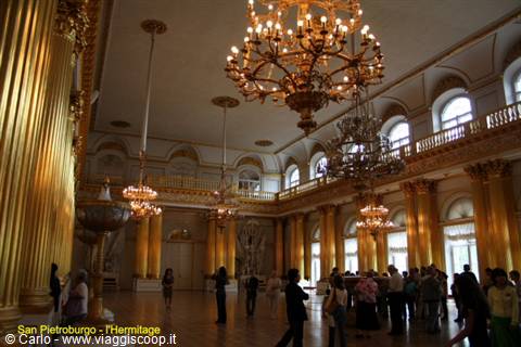 Gilded hall of the Hermitage in Saint Petersburg with chandeliers and visitors