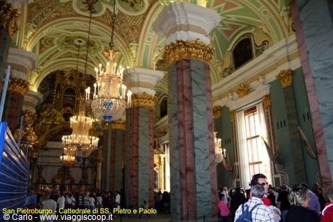 Tourists beneath crystal chandeliers and marble columns in the Peter and Paul Cathedral