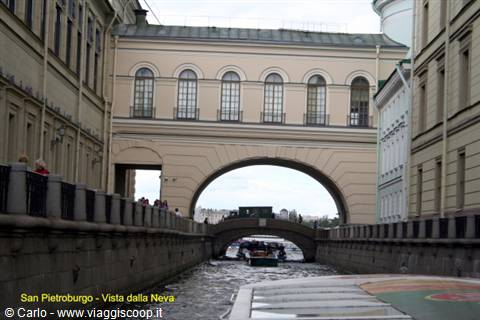 Boat passing under the arched bridge on the St. Petersburg canal
