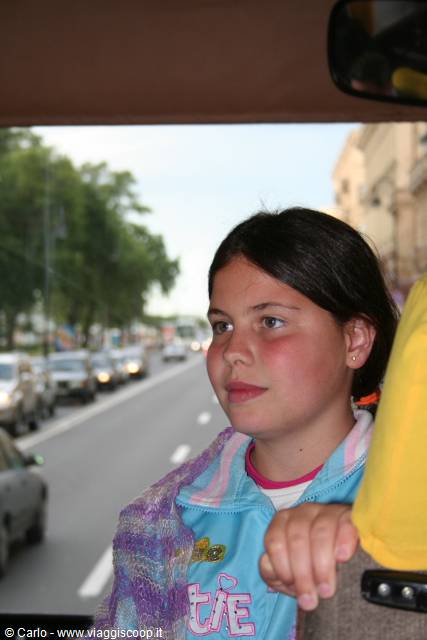 Girl on a bus looking at the busy street outside the window