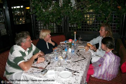 Family dining at restaurant table, printed tablecloth, lit candle, indoor light