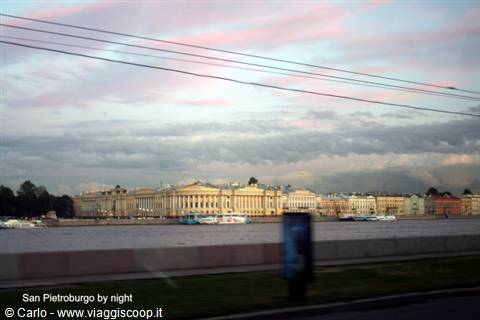 Classical yellow buildings along the Neva river in Saint Petersburg, pink cloudy sky