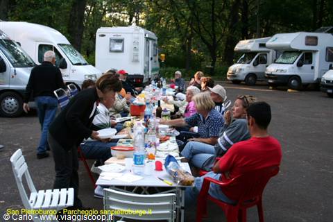 Campers sharing dinner at a long table among motorhomes in Saint Petersburg