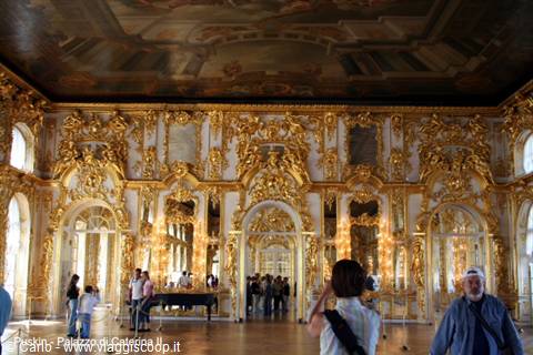 Golden hall of Catherine Palace in Tsarskoye Selo, visitors photographing gilded stuccoes