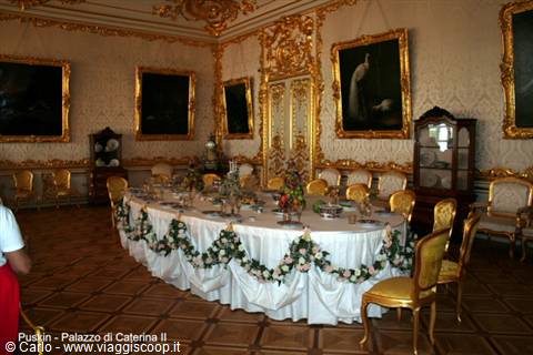 Gilded hall of Catherine Palace in Pushkin, banquet table decorated with flower garlands