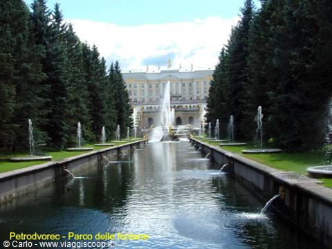 Fountain canal at Peterhof park, palace and firs in the background