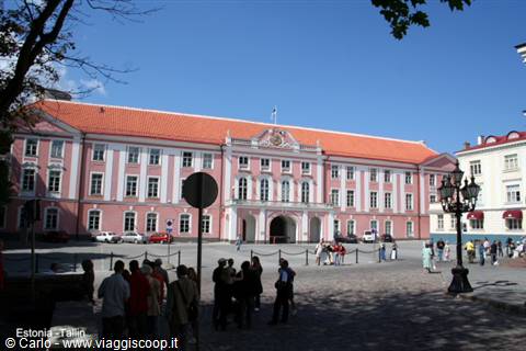 Tourists standing in front of the pink Estonian Parliament building in Tallinn
