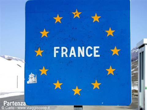 Blue border sign with EU stars at the French frontier, snowy mountains