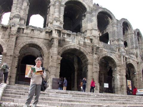 Woman reading a guidebook in front of Arles Roman amphitheatre