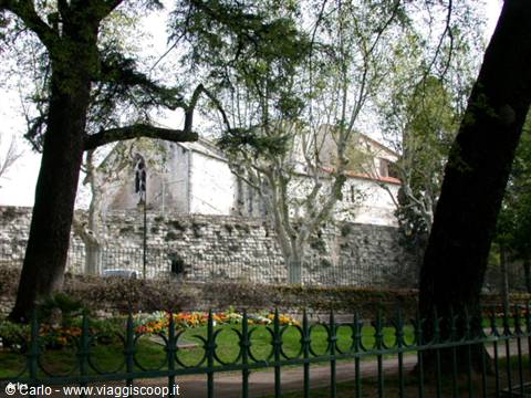 Medieval stone walls among plane trees and flowerbeds, Arles