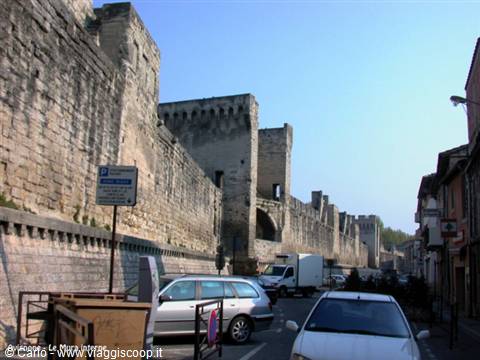 Medieval stone ramparts of Aigues-Mortes, cars parked along the street