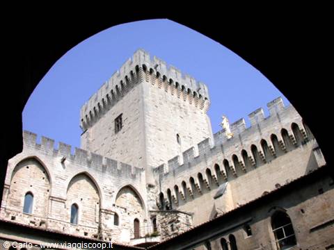 Crenellated tower of Avignon Papal Palace seen through a stone arch