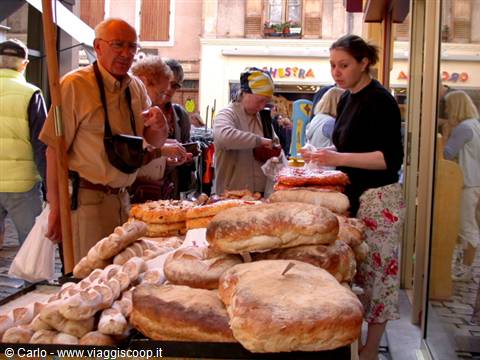 Provence street market: giant breads and focaccia on the stall, shoppers buying
