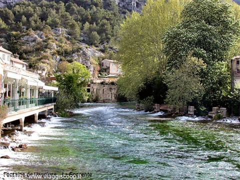 Fontaine de Vaucluse: the spring flows green past houses and trees