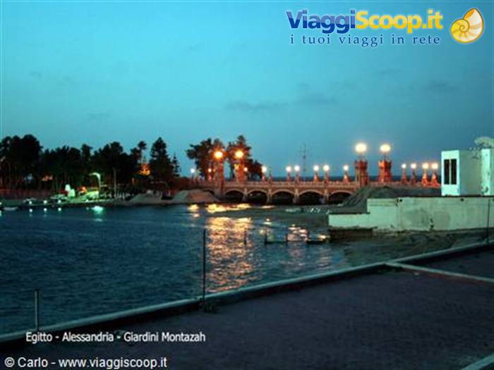 Illuminated bridge at Montazah Gardens, Alexandria, golden lights reflecting on the water at dusk
