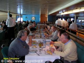 Passengers having lunch at tables in a ferry restaurant hall